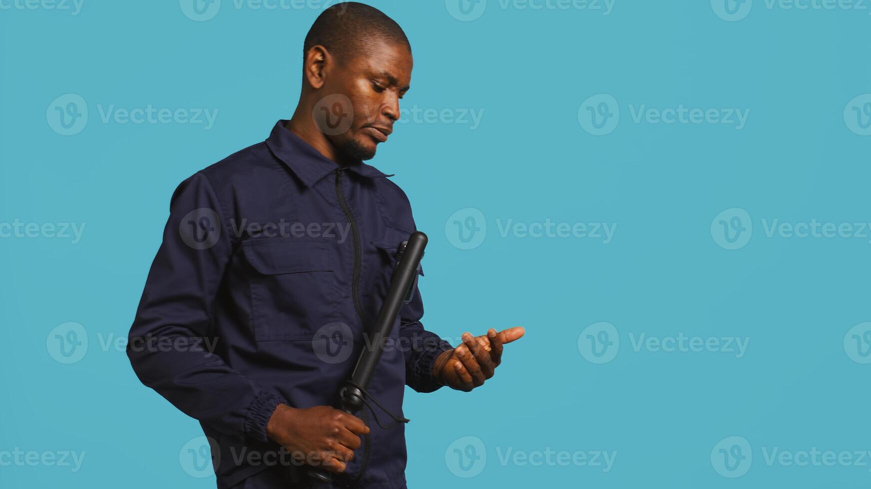 Portrait of security agent patrolling to secure assigned post, wearing bodycam, studio background. Guardian using security surveillance body camera while handling security breaches, camera B photo