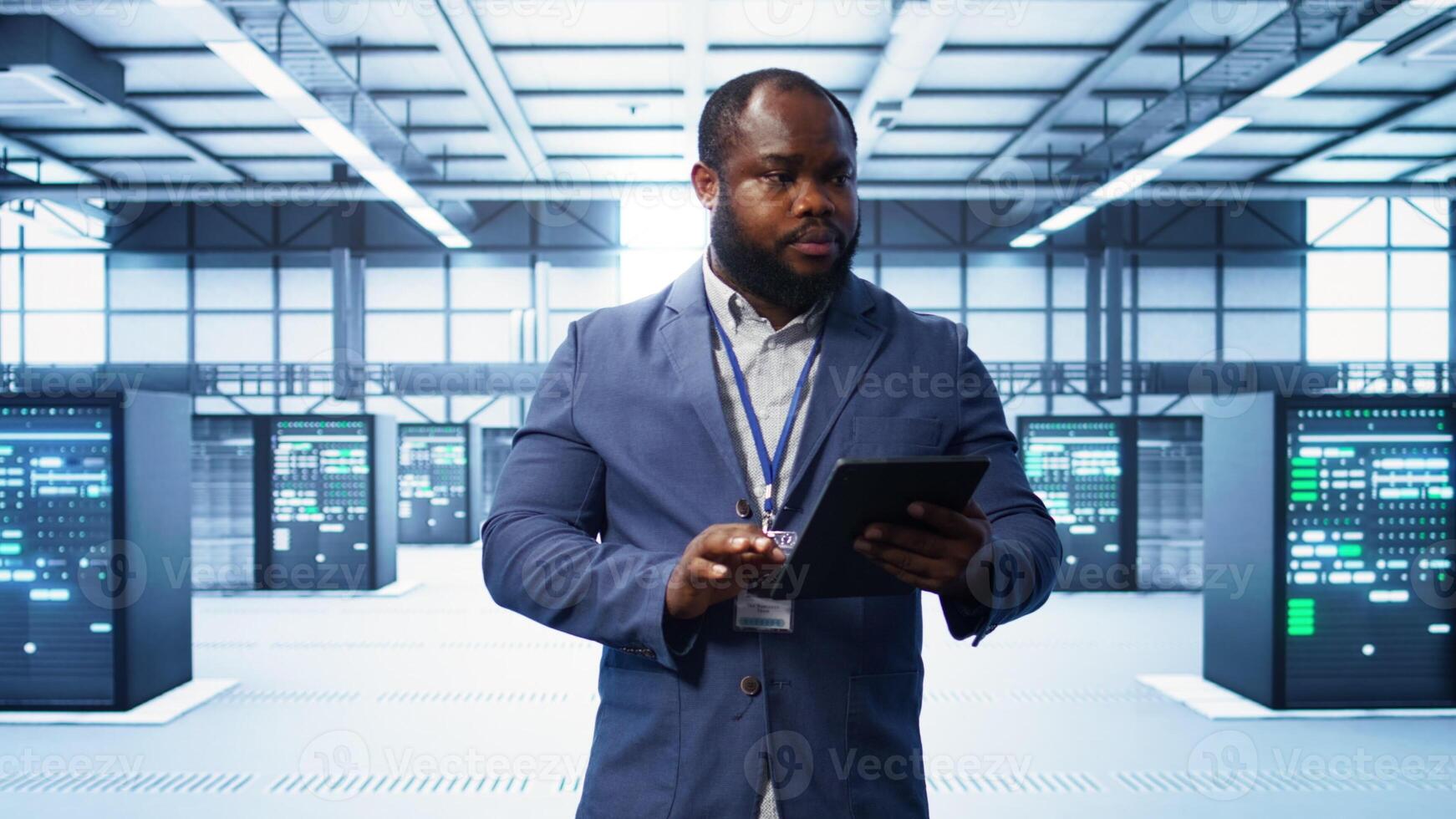 IT technician walking in data center, overseeing server operations using tablet. Expert ensuring optimal performance and data integrity in server hub using digital device, camera B photo