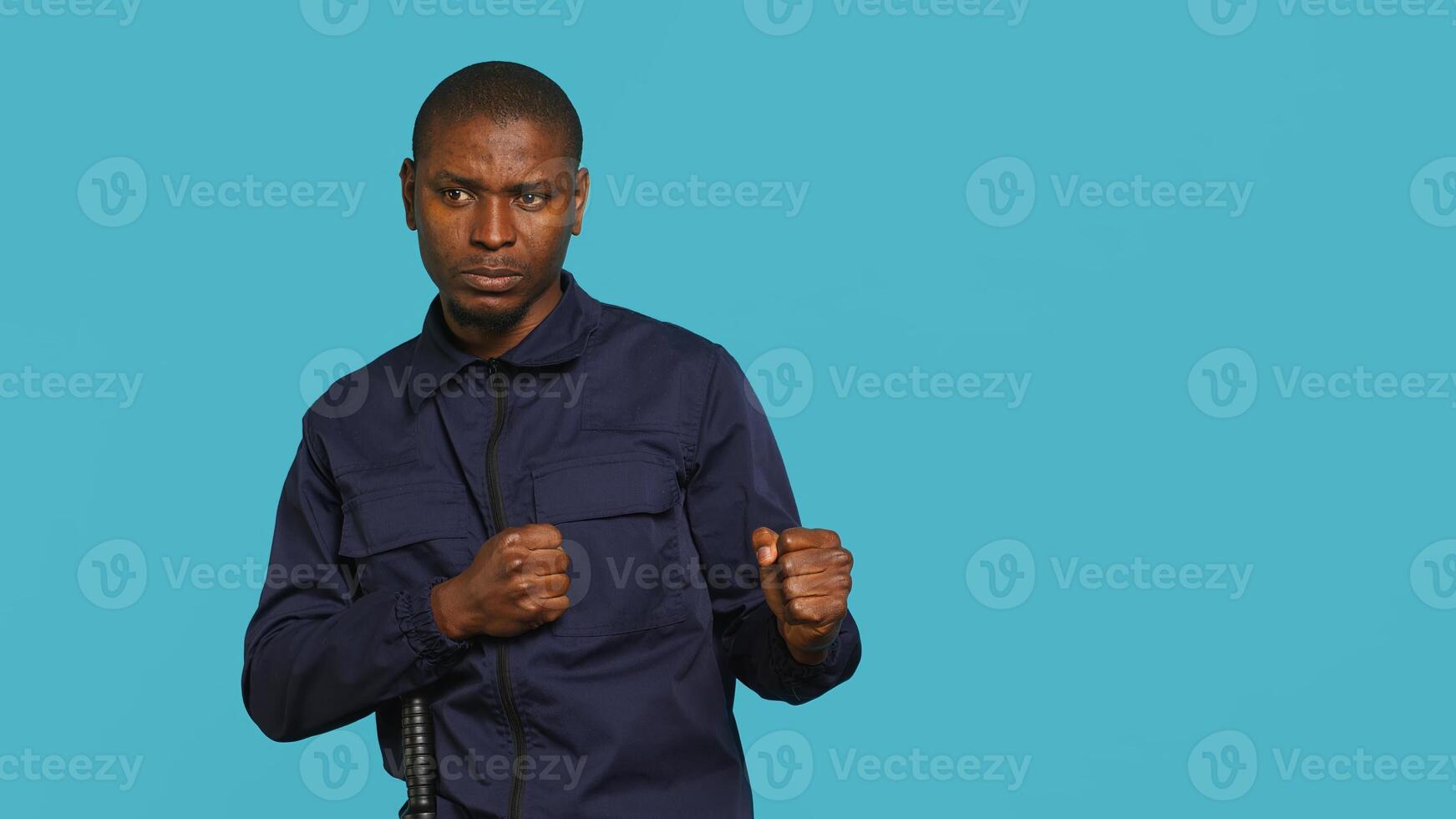 Portrait of tired security guard suffering from painful headache while overseeing premises. Private law enforcement worker feeling ache from fatigue, studio backdrop, camera A photo