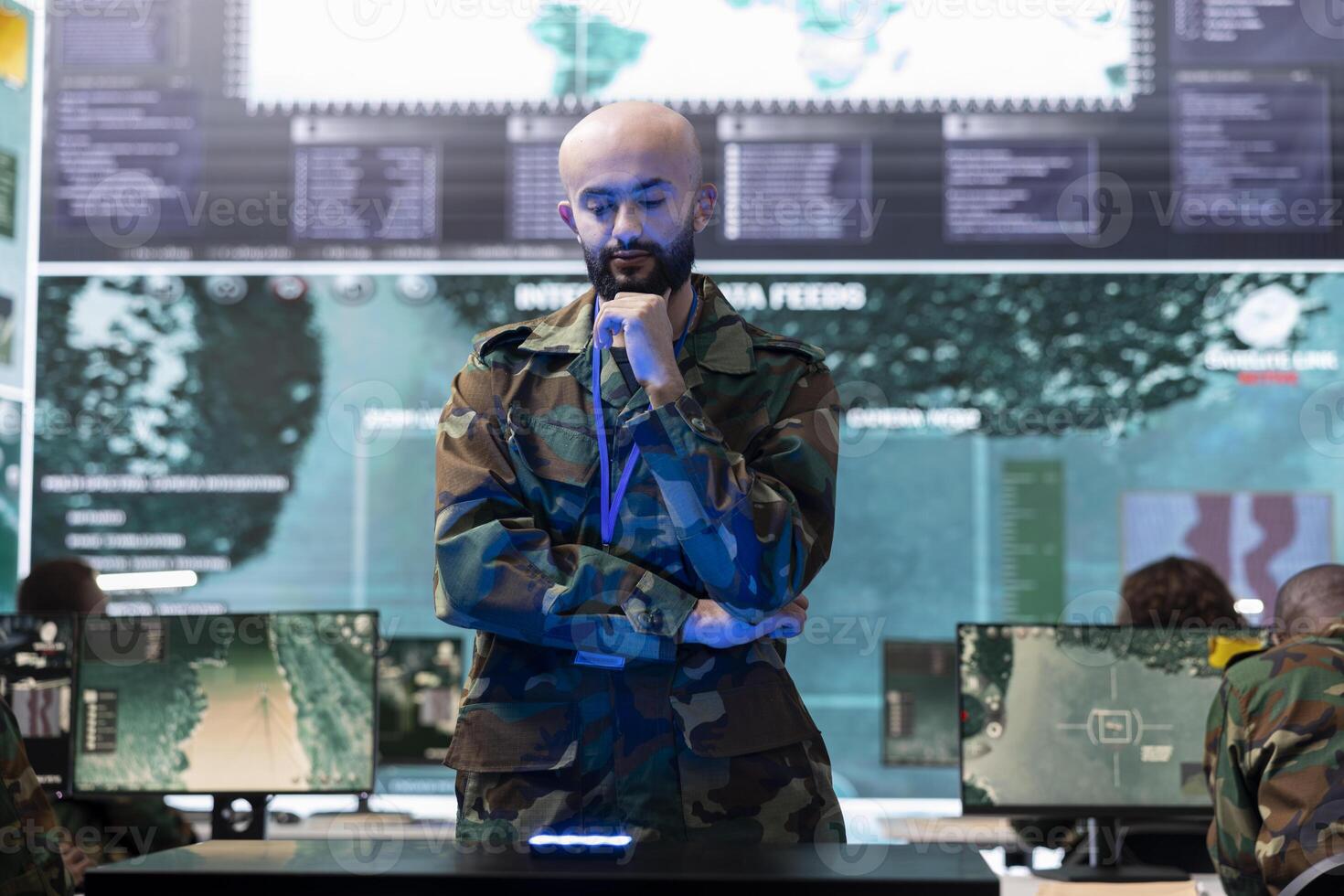 Military staff examining a projection on hologram in command center, working on new defense mission plan. Trooper looking at real time CCTV radar information on a holographic visualization. photo