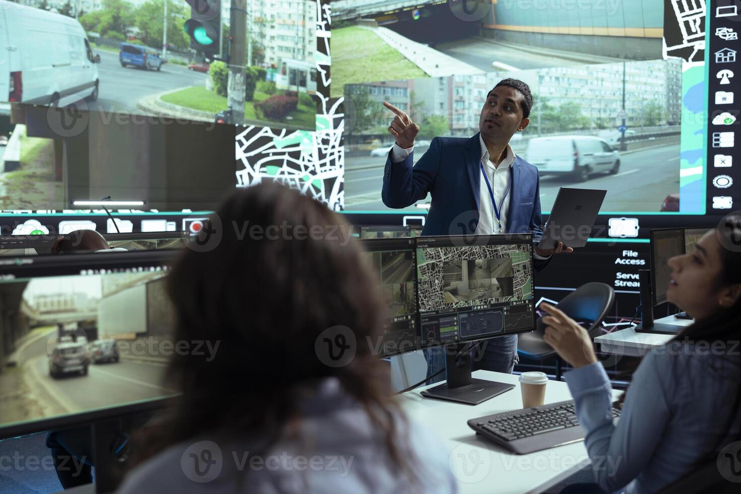 Indian team leader gives insight to his employees at shipping agency headquarters, people working on help couriers deliver their cargo in time. Operators monitoring traffic, gps tracking. photo