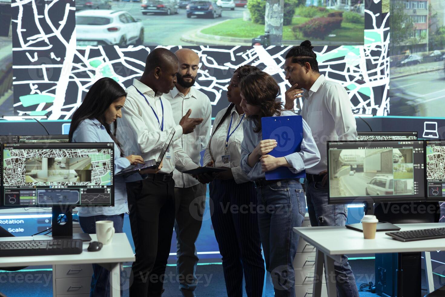 Group of agency employees sharing insight on cargo logistics and gps coordinates to help with order tracking in traffic. Operators use satellite map and CCTV radar cameras, tracing parcels. photo