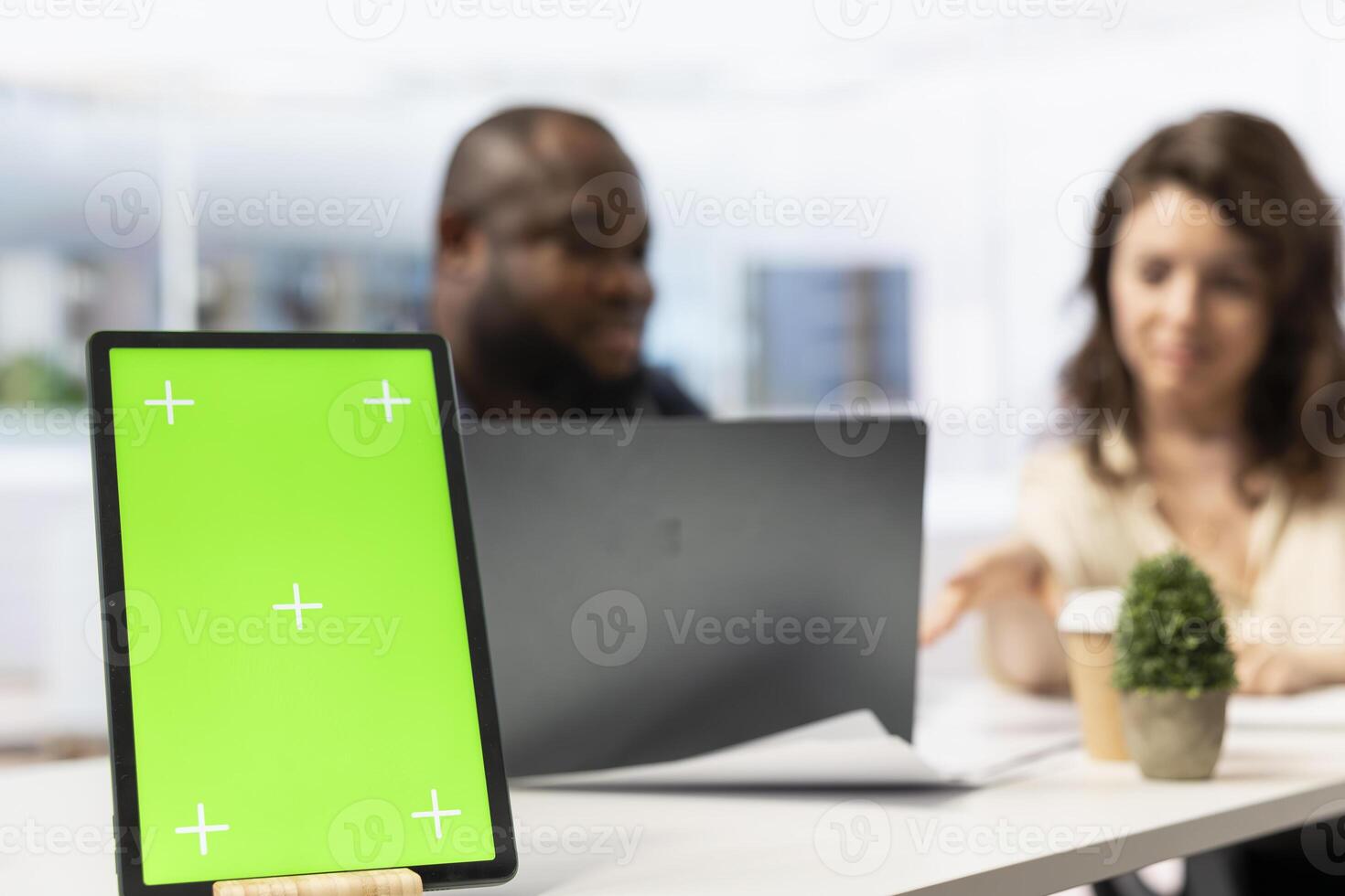 Realtor examining blueprint plans with client next to green screen on tablet, negotiating leasing contract terms for business investment. High class office space for relocation. photo