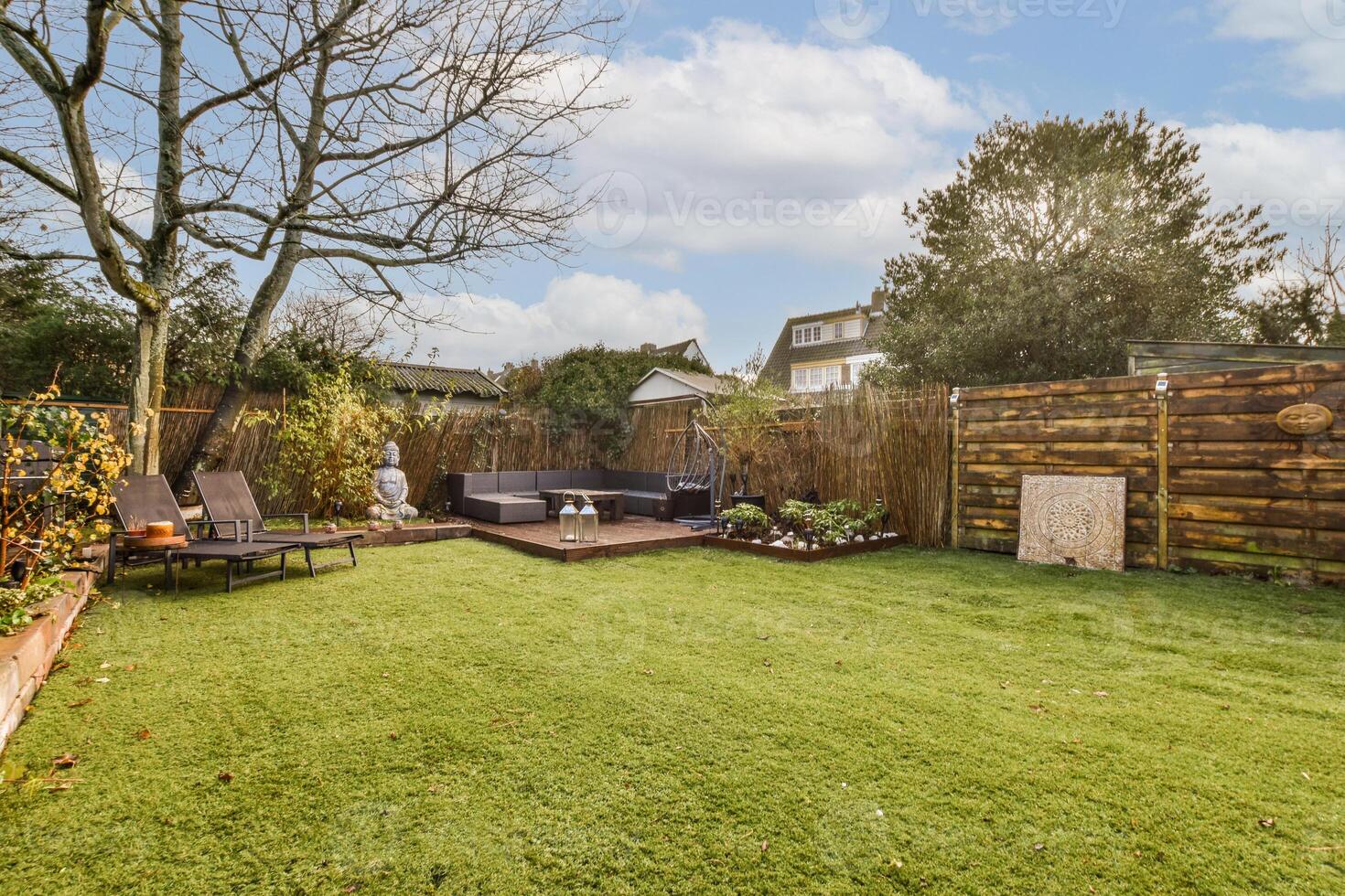 A backyard with a lawn and a wooden fence photo