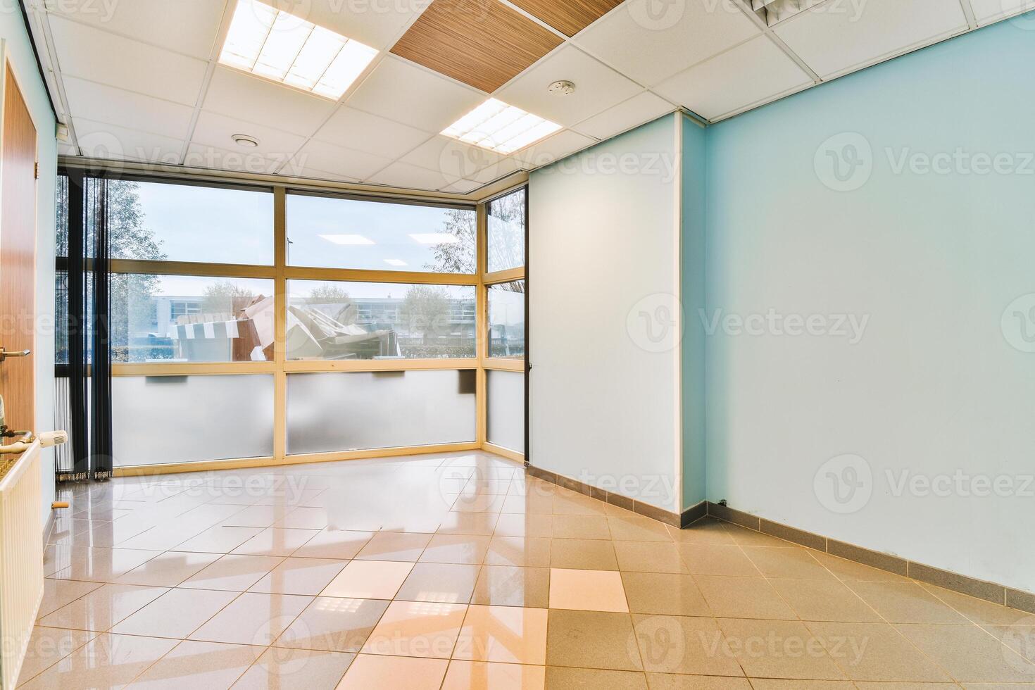 An empty office with a large window and tile floor photo
