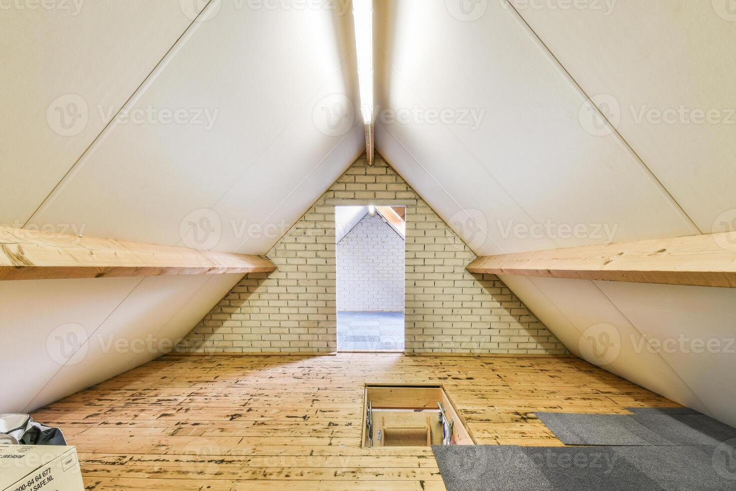 A small attic with a wooden floor and a light photo