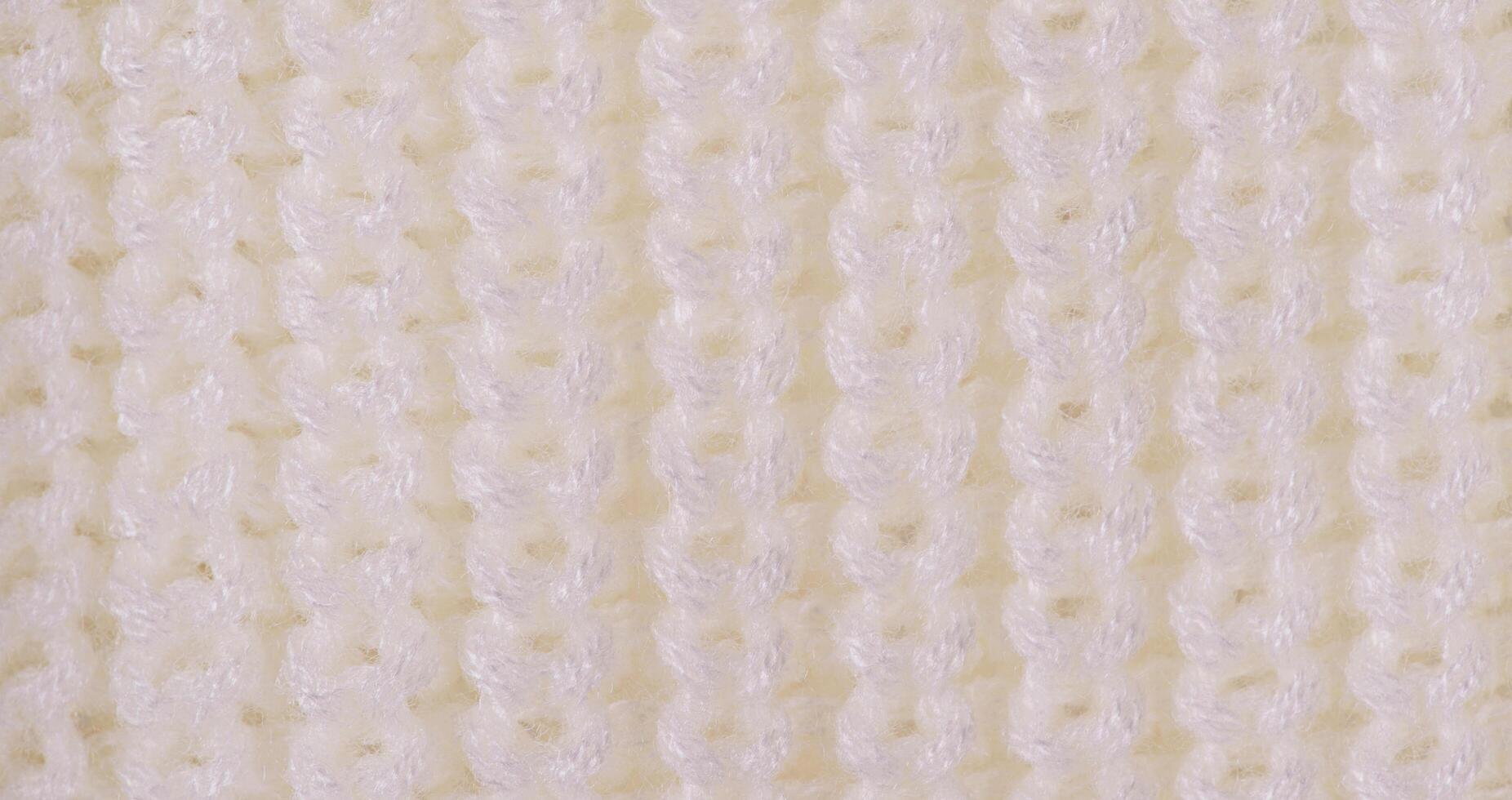 Knitted light background web size. Part of knitted clothes macro photo. photo