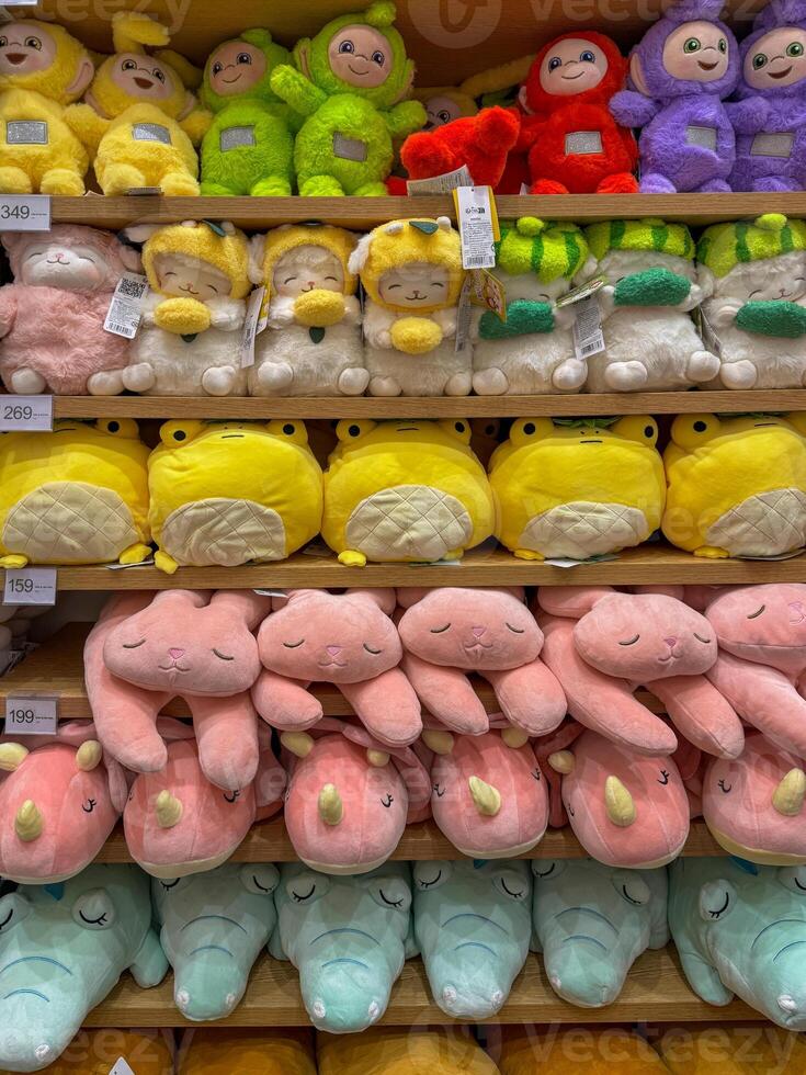 Soft toys on the shelves in a children's store for sale photo