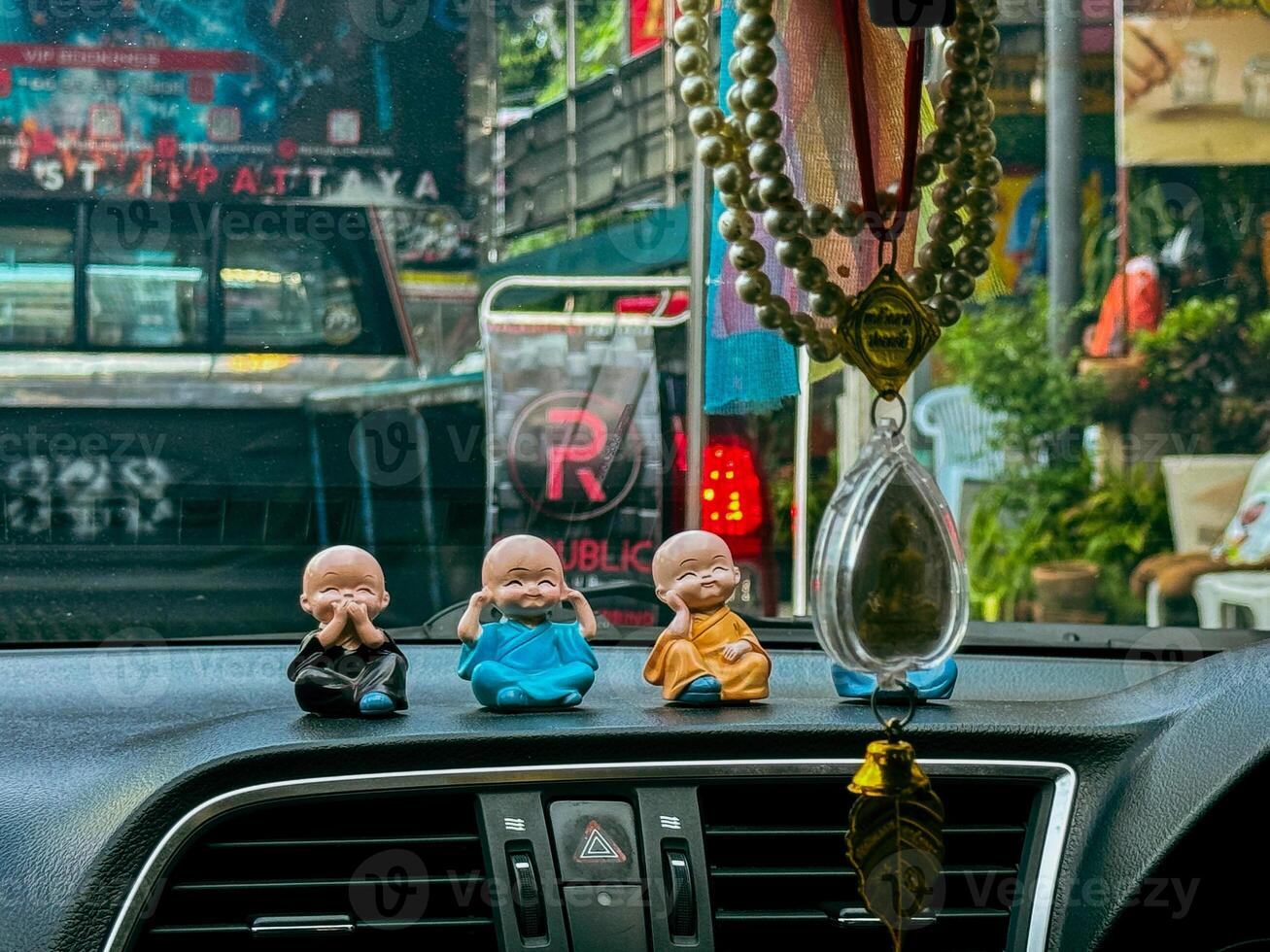 ceramic figures of Buddha on the cab driver's dashboard photo