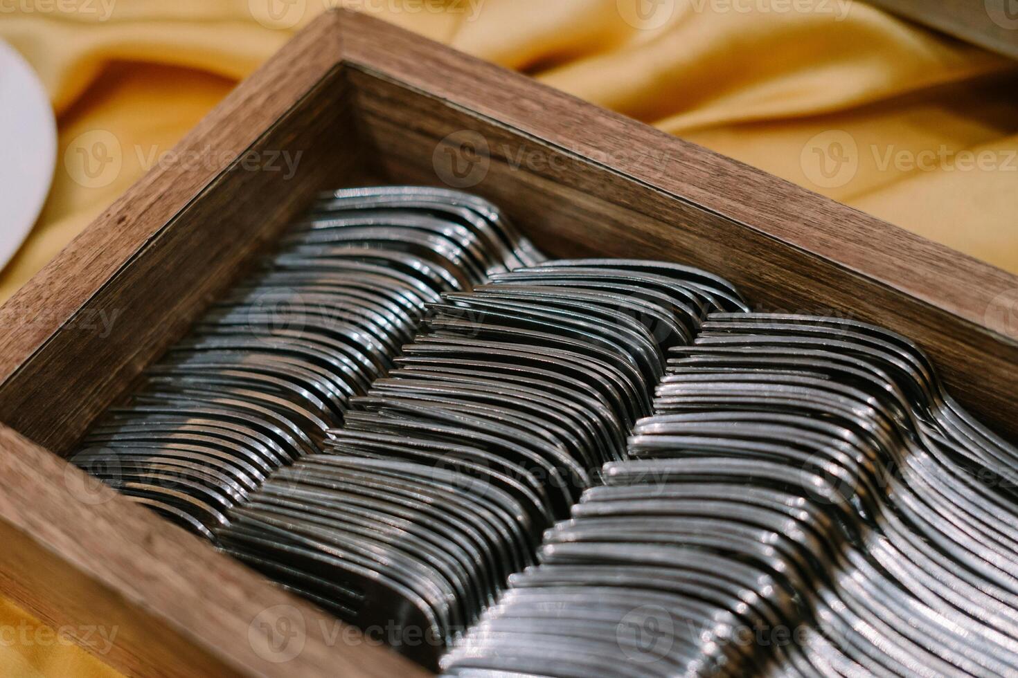 A dining fork placed in a rustic wooden holder photo
