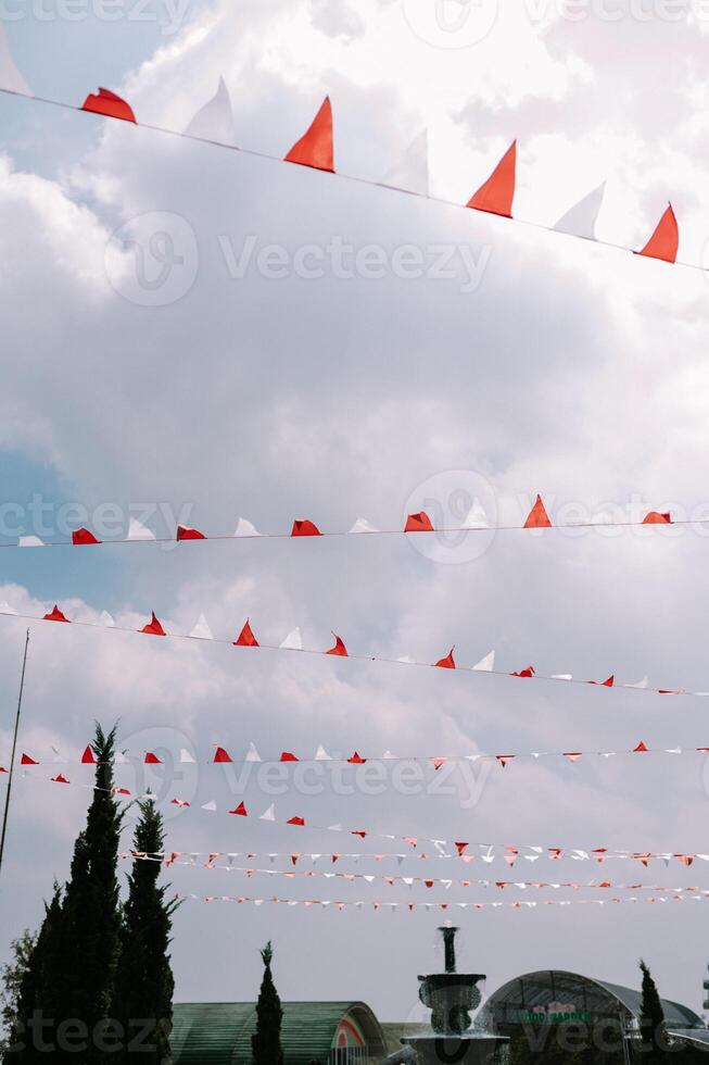Street decorations featuring red and white paper streamers hanging from strings across the sky photo