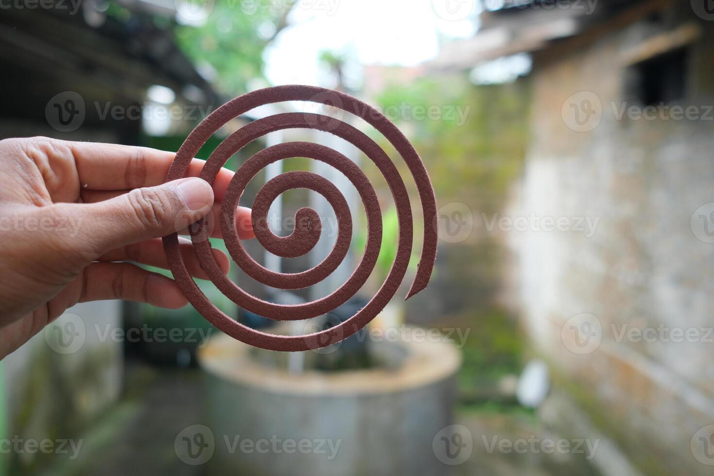 Close-up of a brown mosquito repellent coil held in a hand. photo