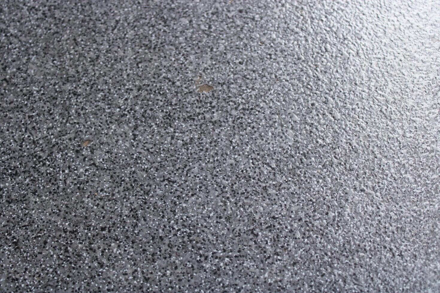 Close-up of rough textured gray surface with white specks. photo