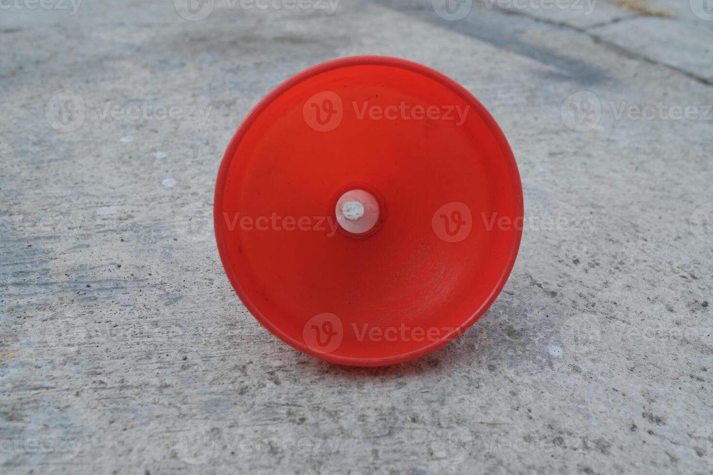 Red plastic funnel on a concrete surface. photo