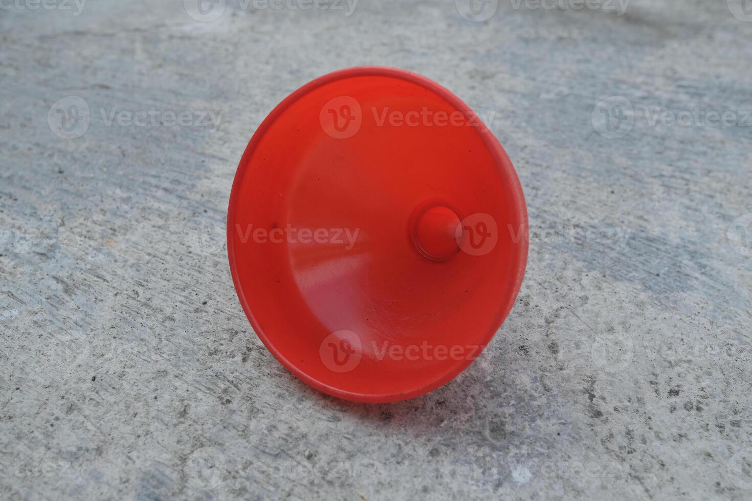 Red plastic funnel on a concrete surface. photo
