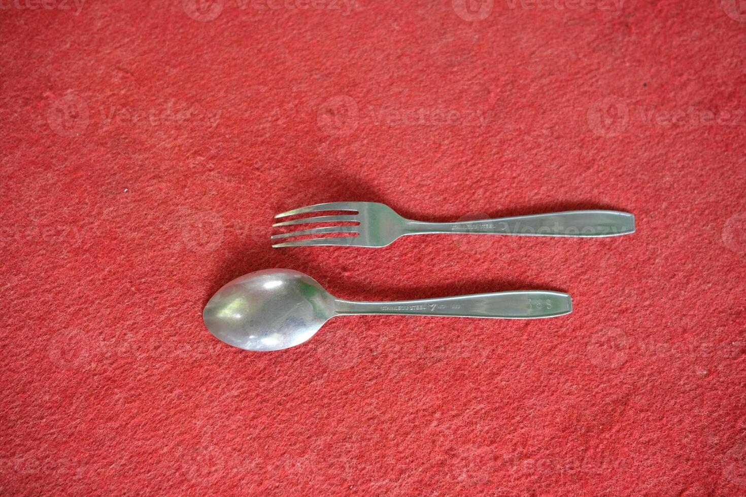 A silver fork and spoon on red felt. photo