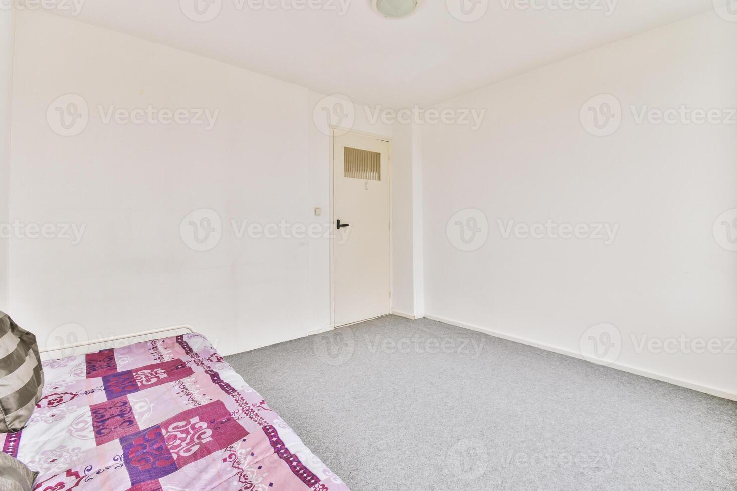A room with a bed and a white wall photo