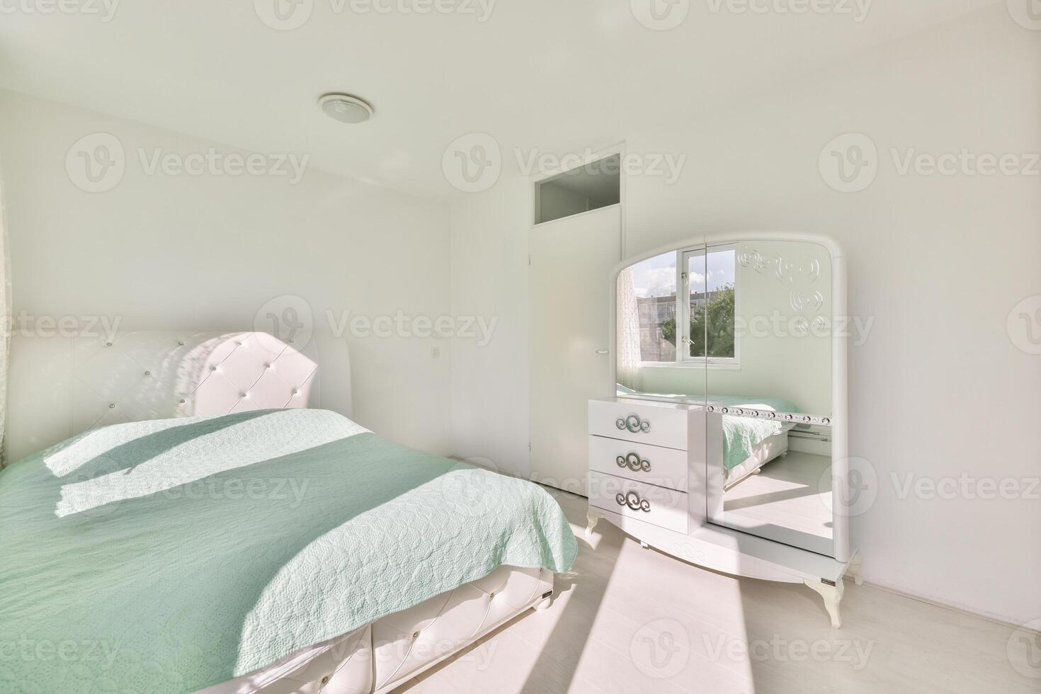 A bedroom with a white bed and a mirror photo
