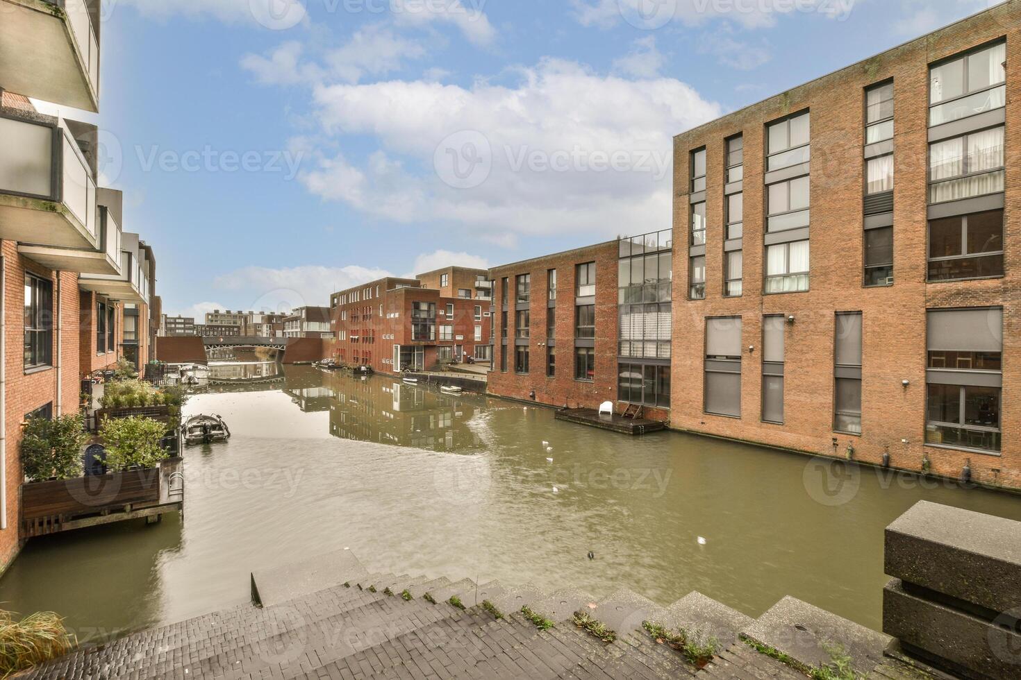 A canal in front of some buildings with a boat in the water photo
