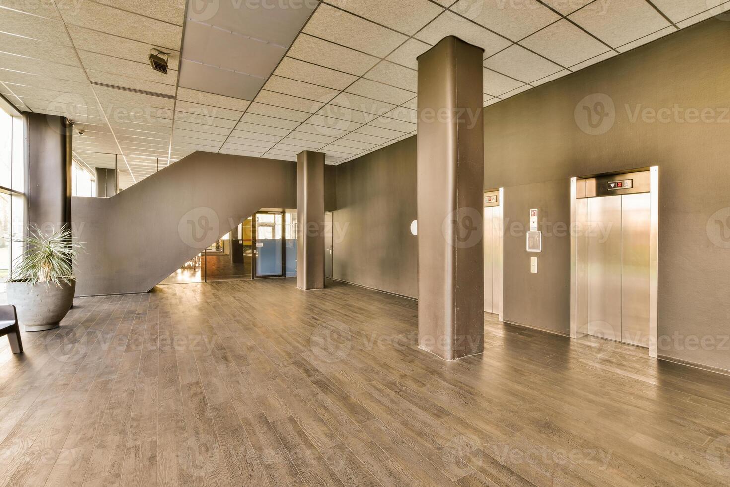 An empty hallway with wooden floors and a large elevator photo