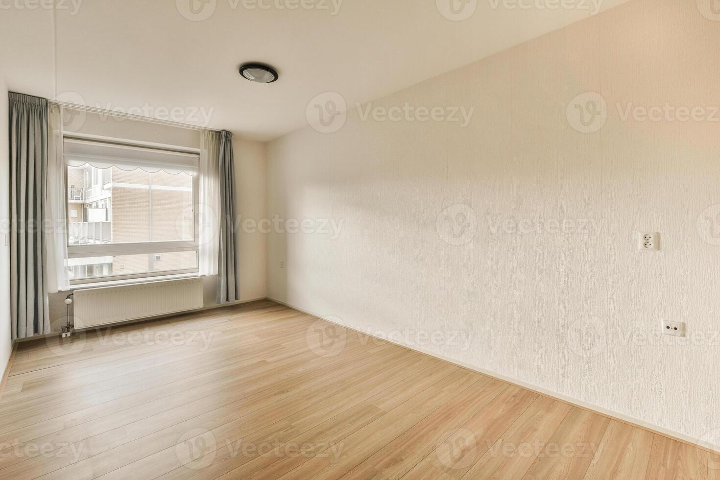 An empty room with wooden floors and a window photo