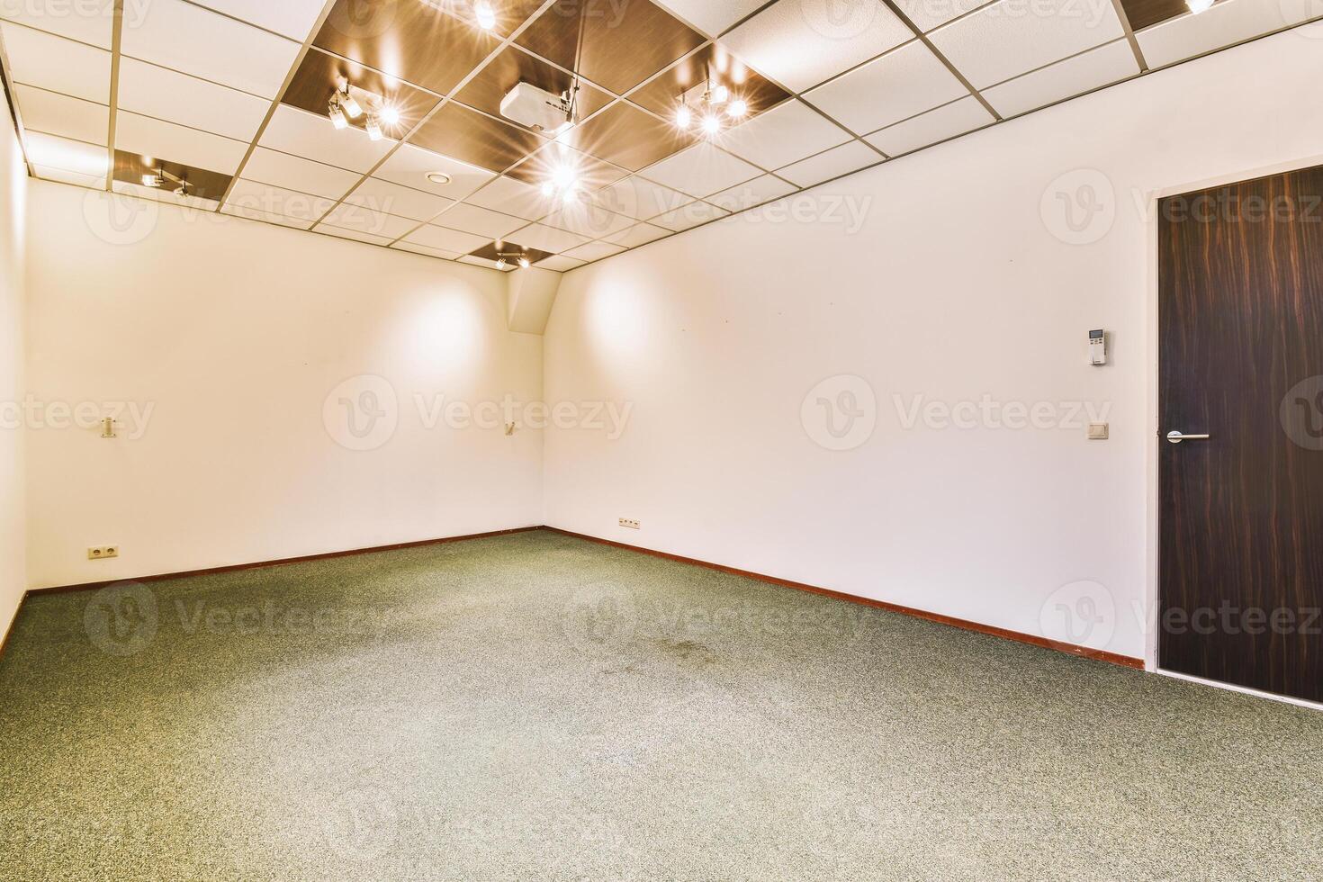 An empty office with a ceiling fan and carpet photo