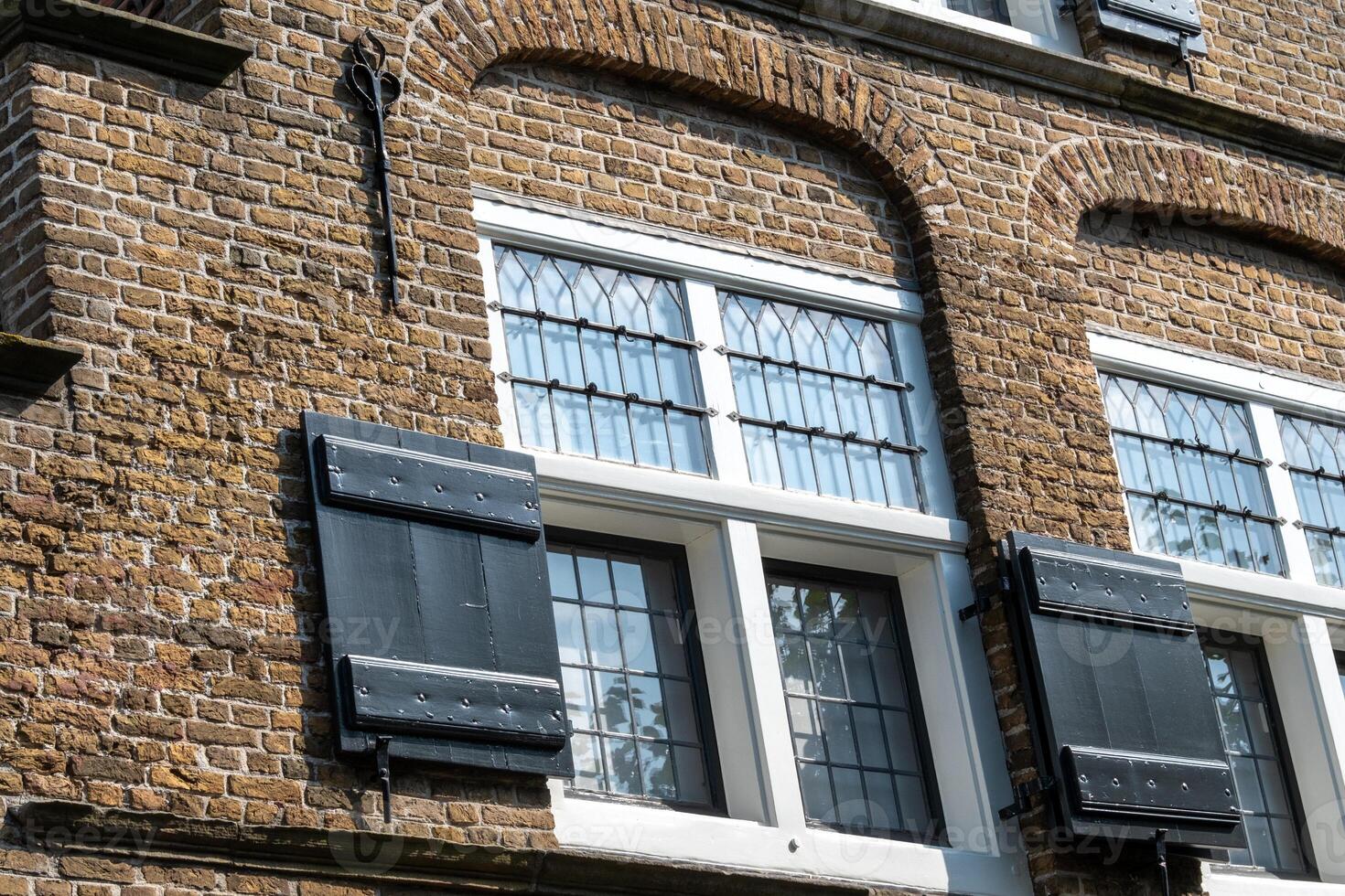 Window with shutters on a medieval building in the netherlands photo
