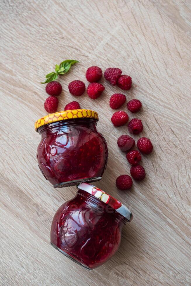 Raspberries spread over a jar of jam photo
