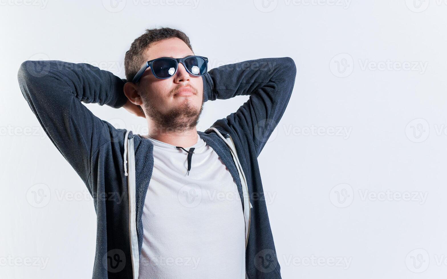 Handsome guy in sunglasses relaxed with hands behind his head, Vacation concept photo