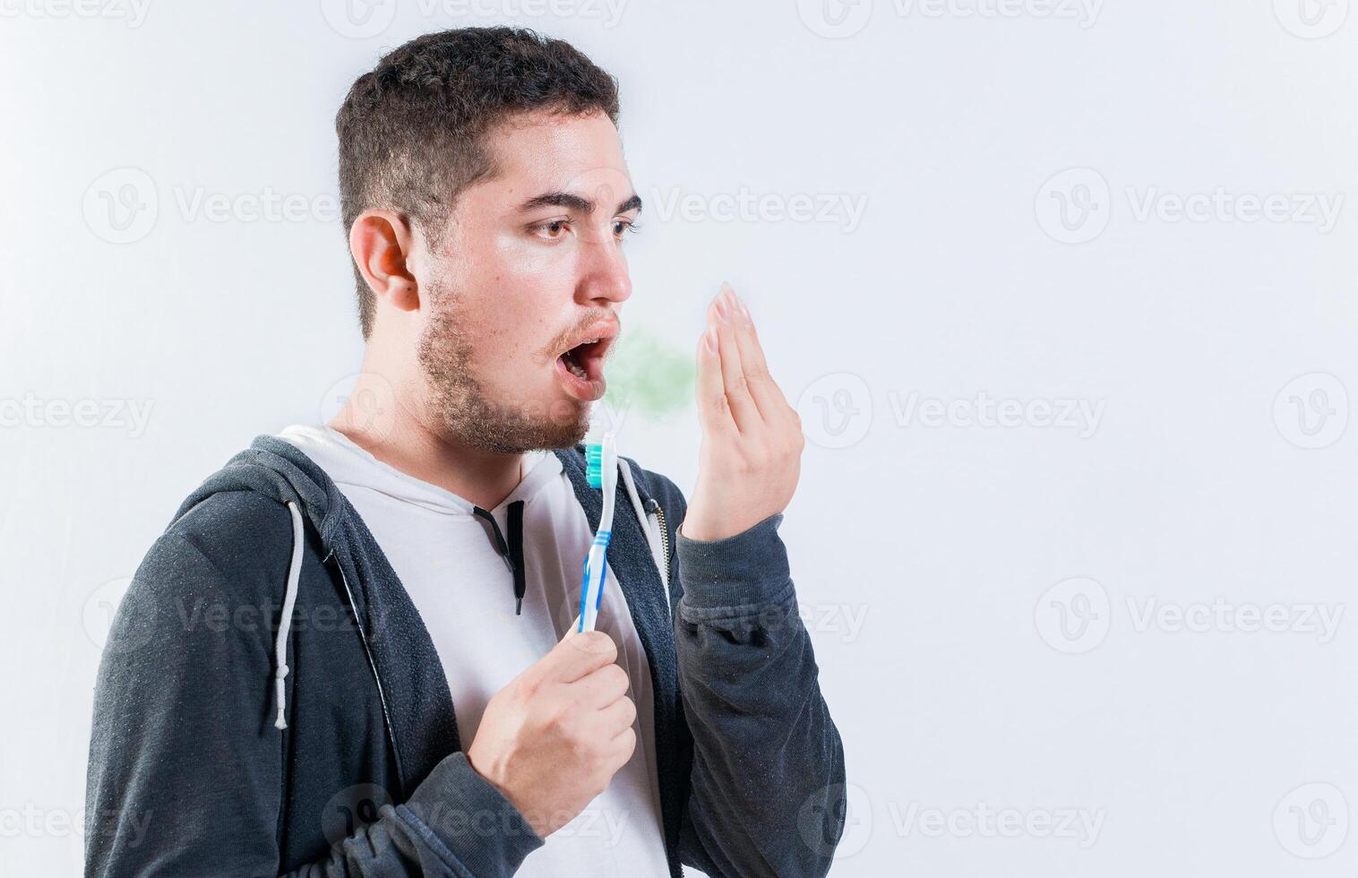Man holding brush checking bad breath. Person holding brush with bad breath problem photo