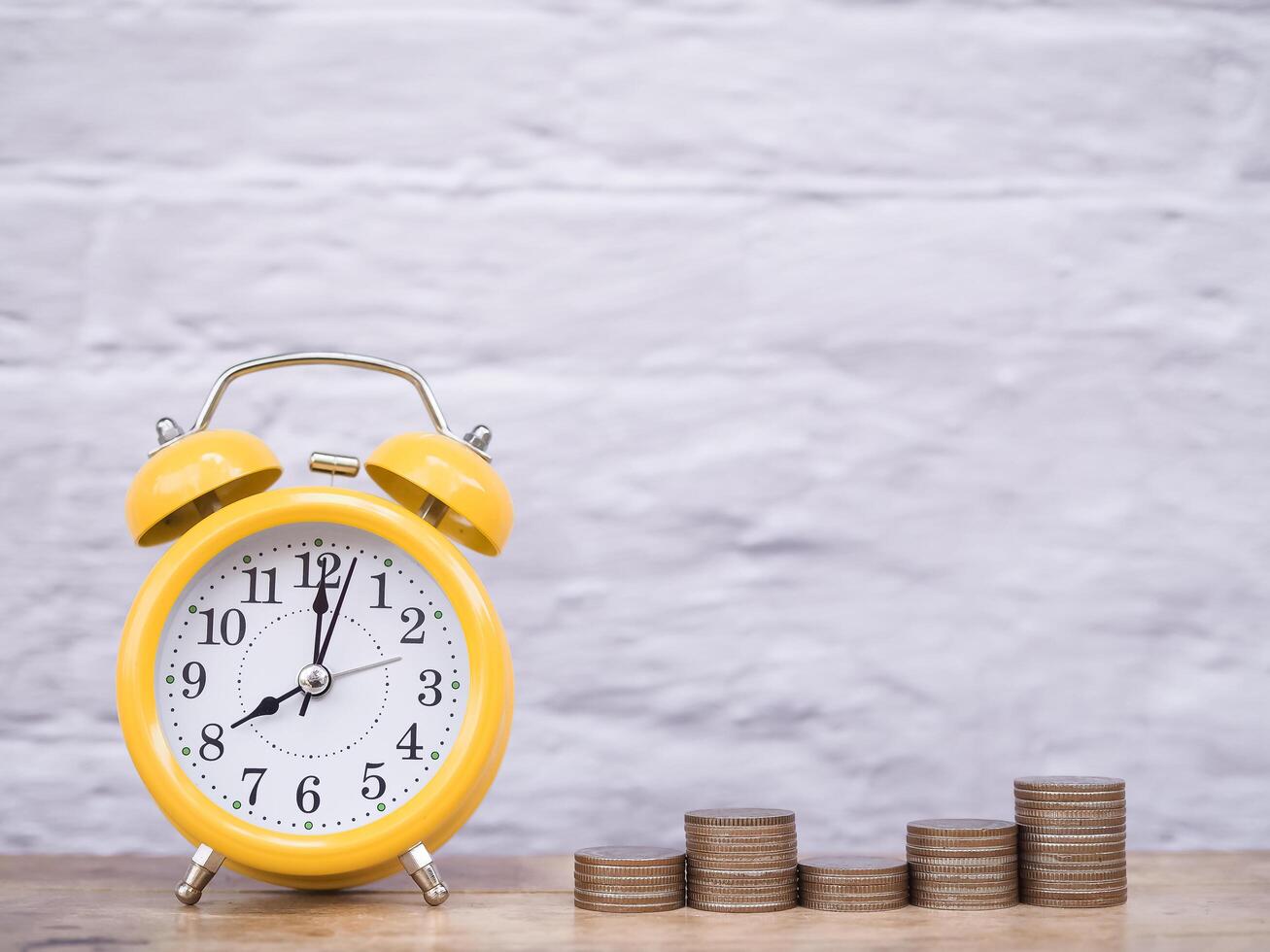 Yellow alarm clock and stack of coins. The concept of saving money and manage time to success business, Financial, Investment and Business growing up. photo