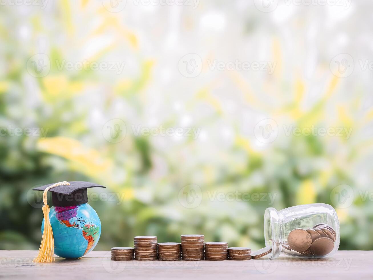 Earth globe with graduation hat on stack of coins. The concept of saving money for education, student loan, scholarship, tuition fees photo