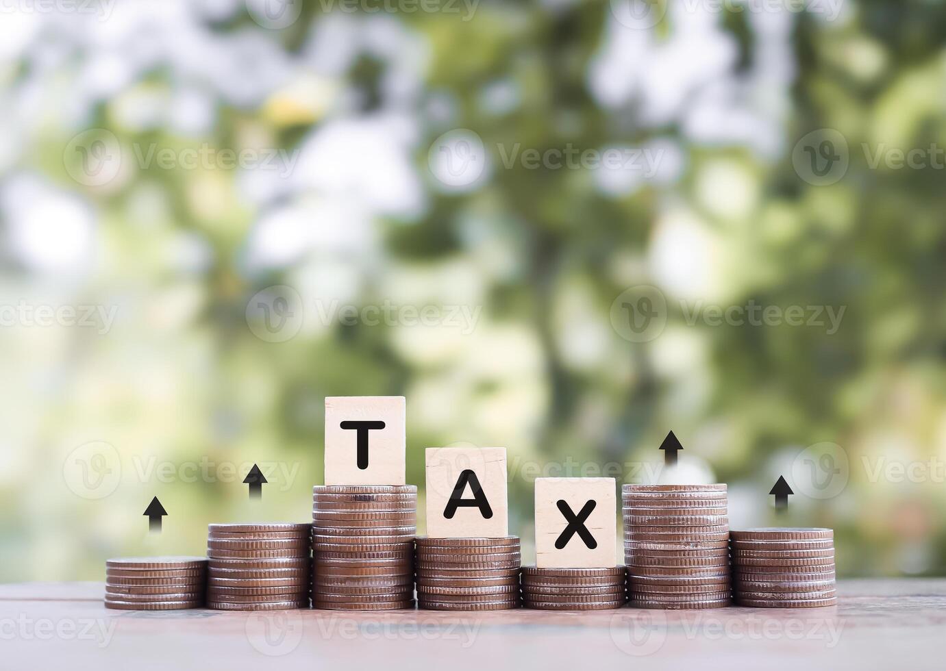 Wooden blocks with the word TAX on stack of coins with arrow rising up. The concept about saving money and manage time to paying tax photo