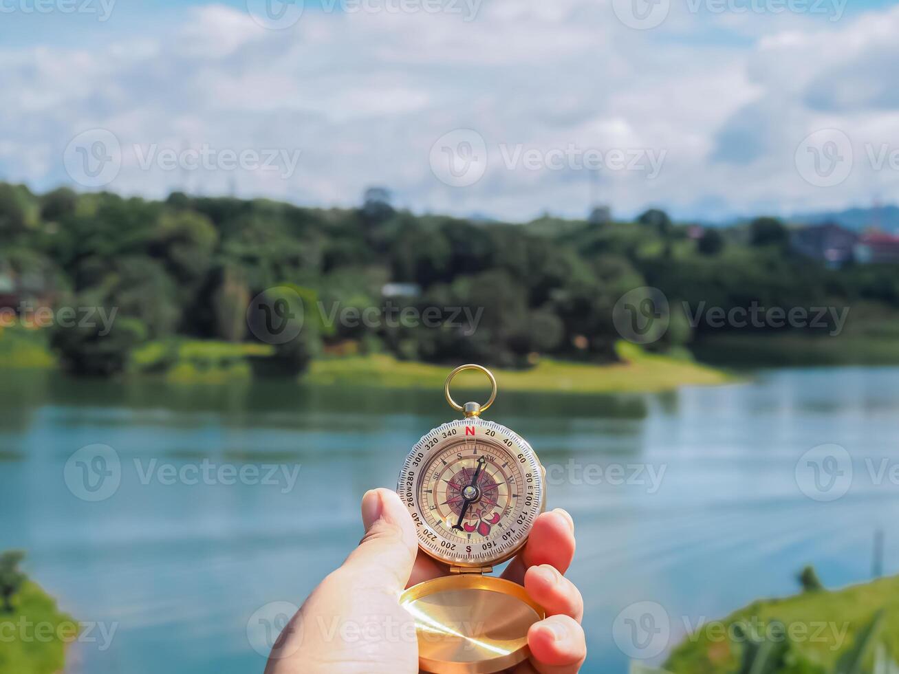 Close up of compass in woman hand with nature as background. The concept of world tourism day, Searching the right directions and Travel photo