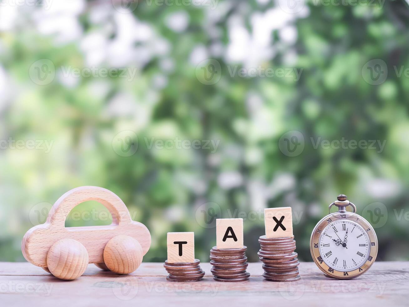 Vintage watch, Wooden toy car and wooden blocks with the word TAX on stack of coins. The concept of saving for paying tax. Manage time to success transportation, Car loan photo