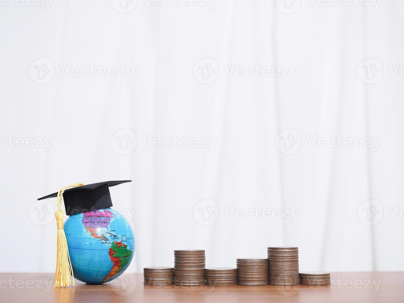 Earth globe with graduation hat and stack of coins. The concept of saving money for education, student loan, scholarship, tuition fees in the future photo