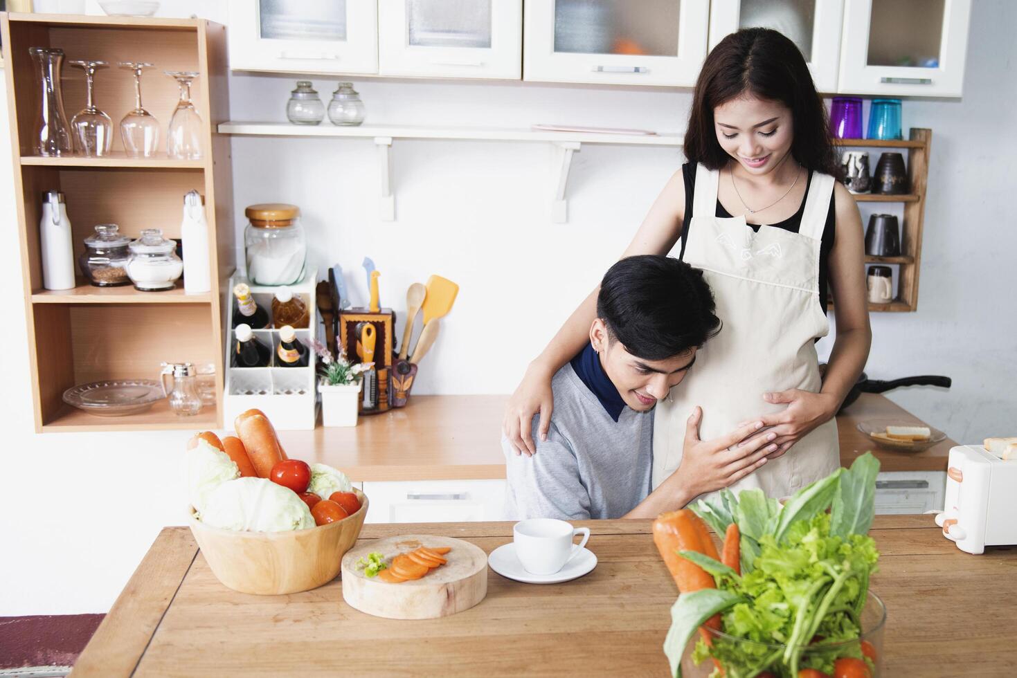 A family of pregnant women and couples are preparing a healthy meal with green vegetables at home. photo