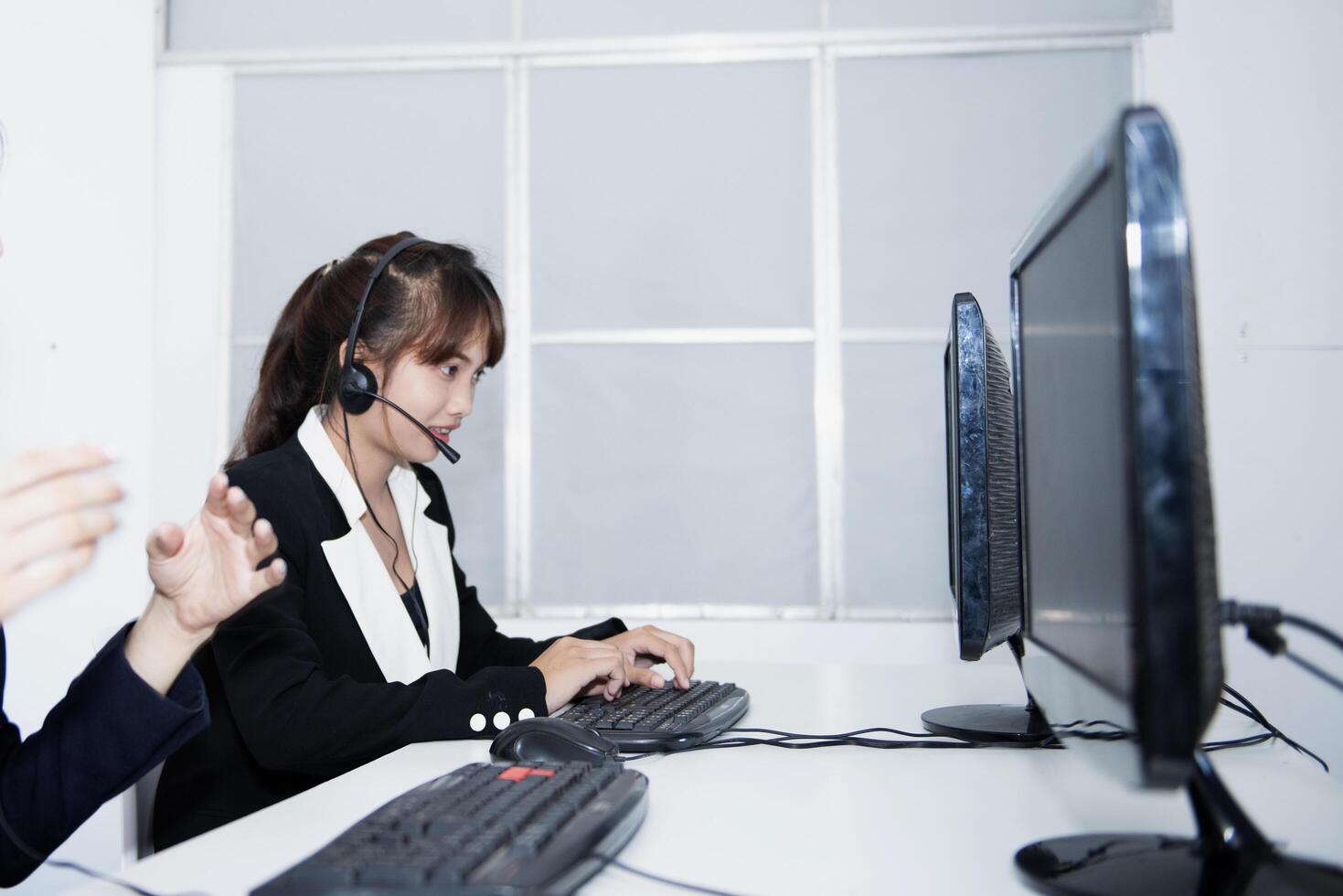call center smiling business operator customer support team phone services agen working and talking with headset on desktop computer at call center photo
