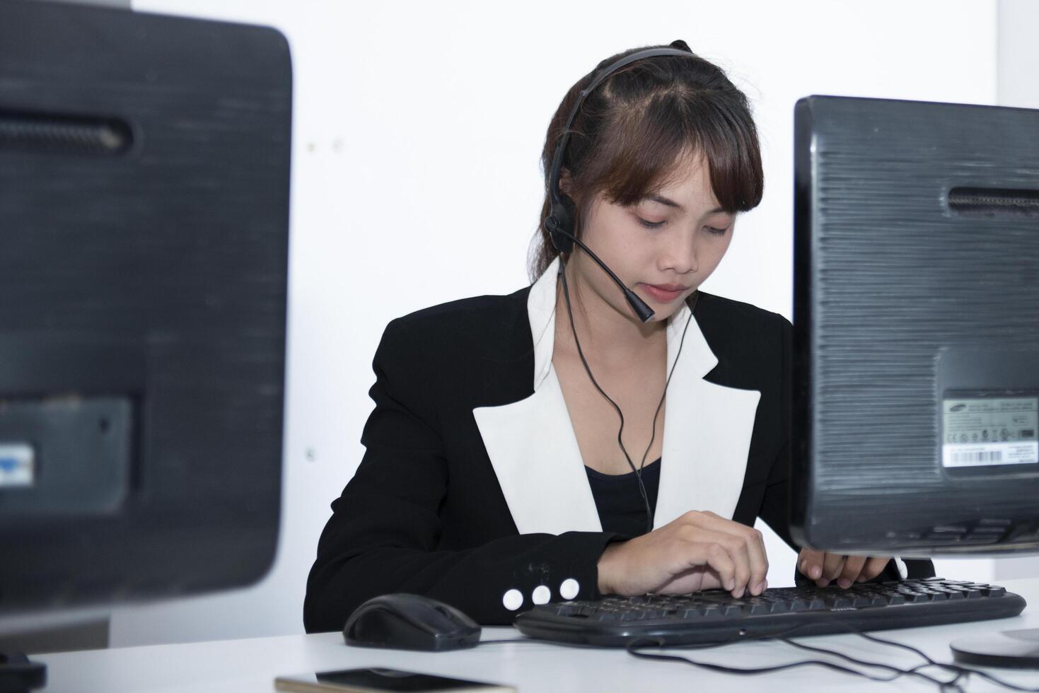 call center smiling business operator customer support team phone services agen working and talking with headset on desktop computer at call center photo