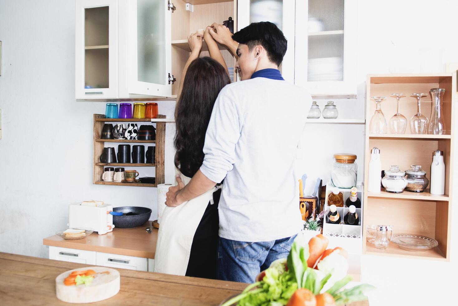 A family of pregnant women and couples are preparing a healthy meal with green vegetables at home. photo