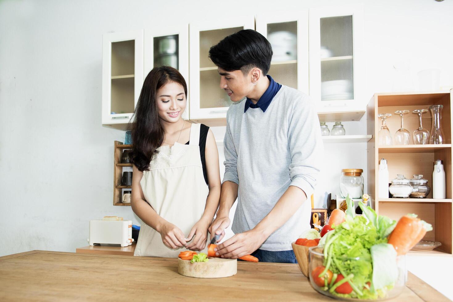 A family of pregnant women and couples are preparing a healthy meal with green vegetables at home. photo