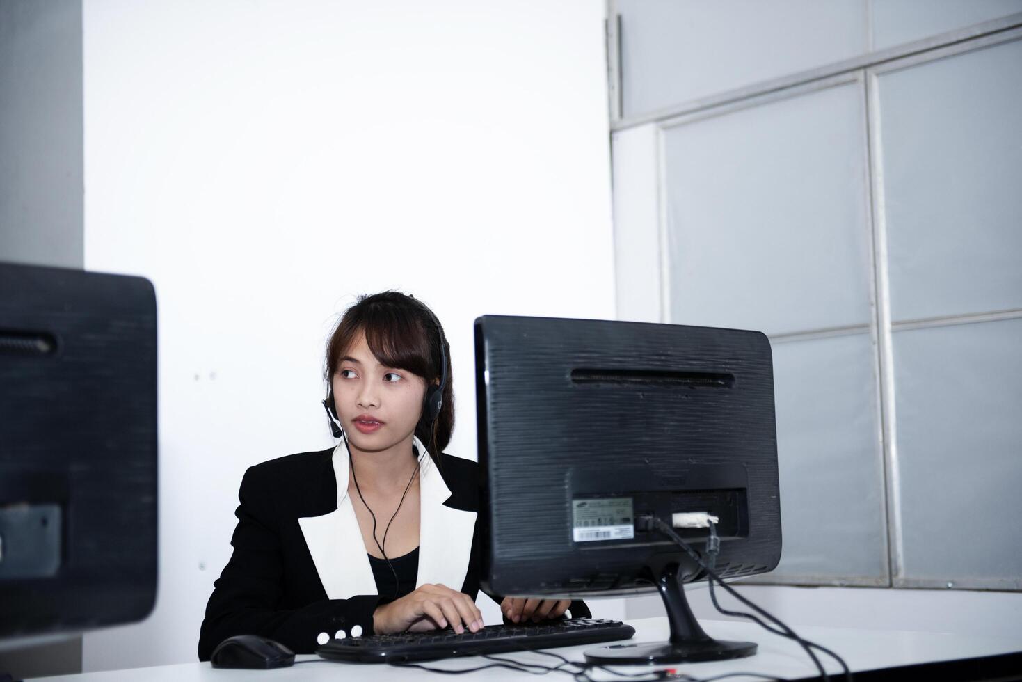 call center smiling business operator customer support team phone services agen working and talking with headset on desktop computer at call center photo