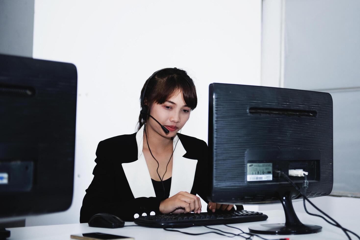 call center smiling business operator customer support team phone services agen working and talking with headset on desktop computer at call center photo