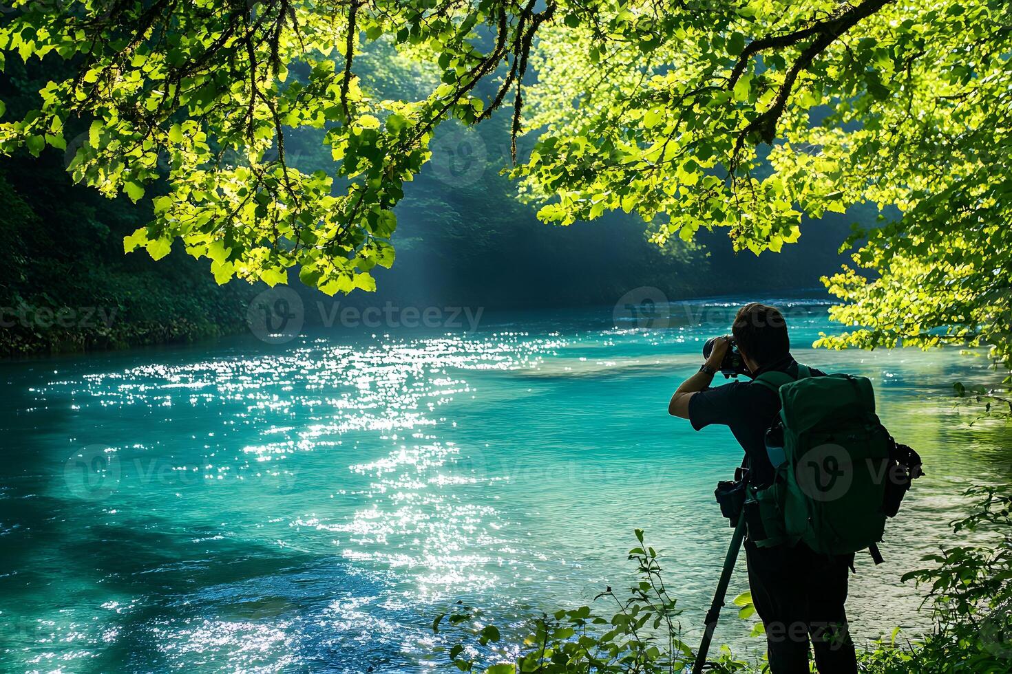 a man with a backpack taking a picture of a river photo