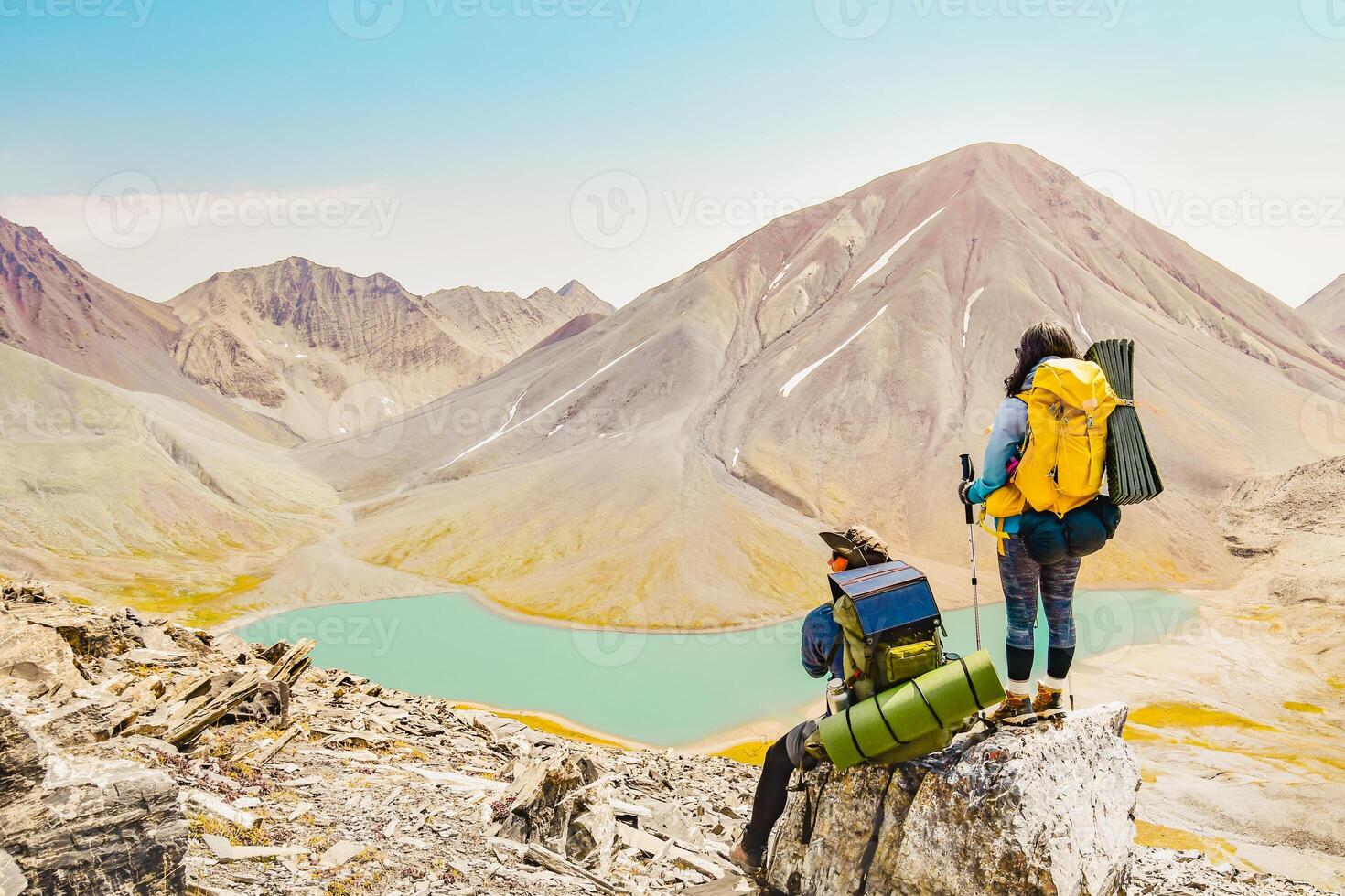 Aerial rising view young woman Hiker standing and watching beautiful alpine lake and mountains in country Georgia. Kazbegi, Kelitsadi lake, Georgia photo