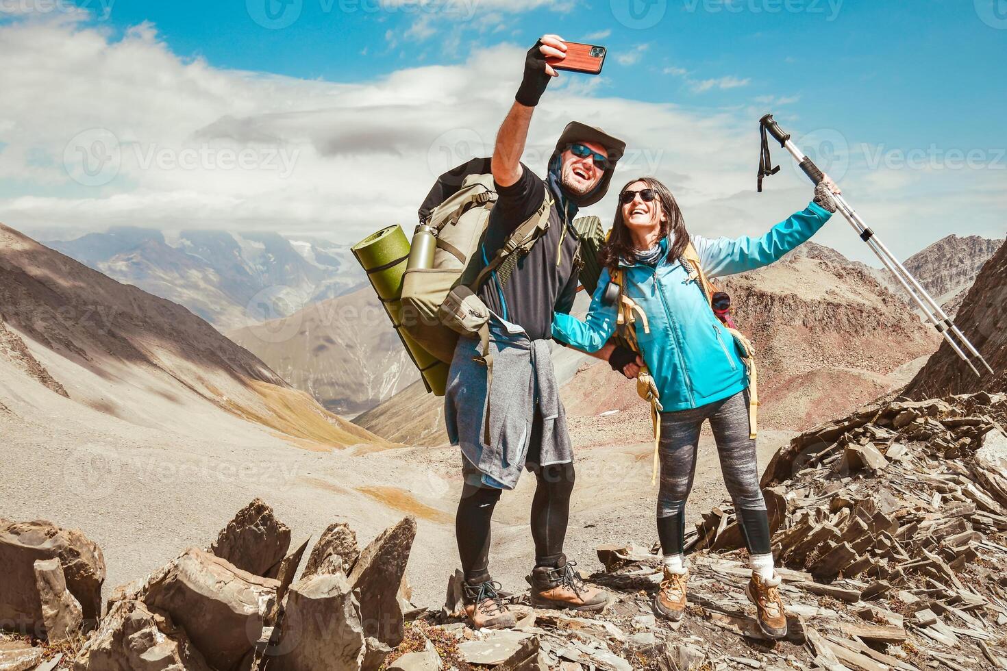 Happy couple of hikers taking selfie portrait on the top of the mountain - Smiling tourists enjoying summer day out - Boyfriend and girlfriend havin photo