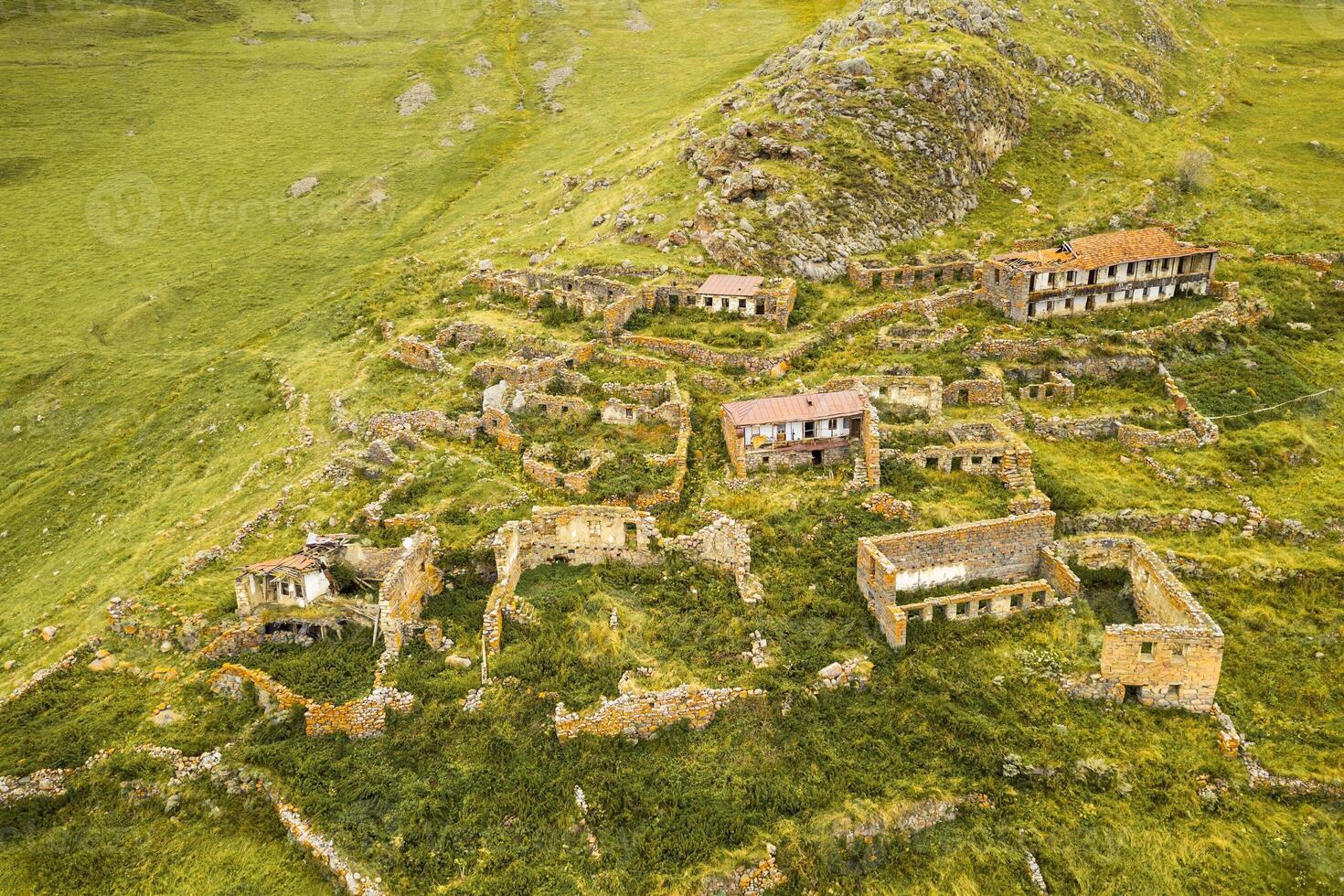 Aerial top view abandoned village of Arsha ruins on hillside. Kazbegi national park. Hidden gem sightseeing attraction in Georgia caucasus mountains photo