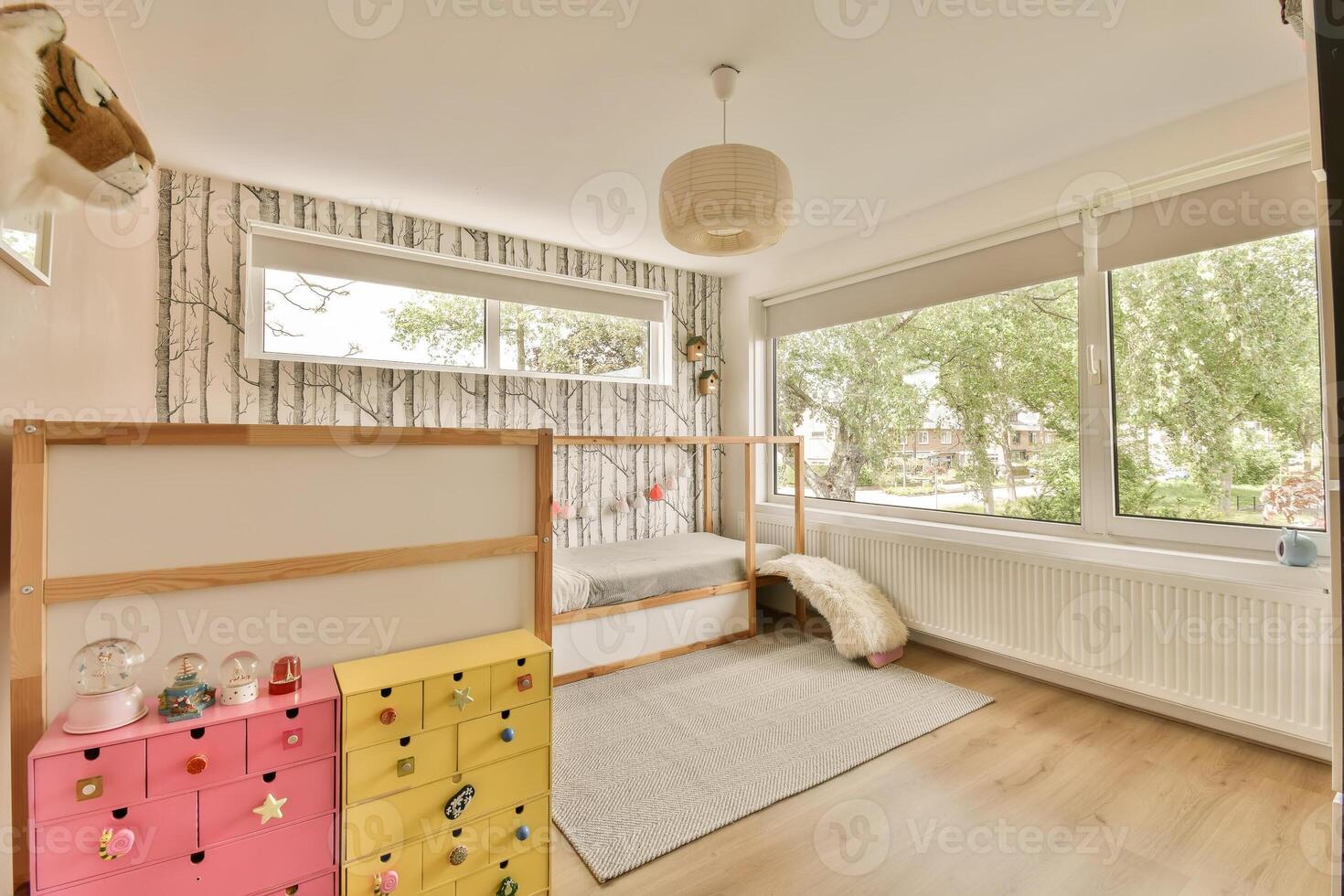 A small room with a bed, a toy box and a window photo