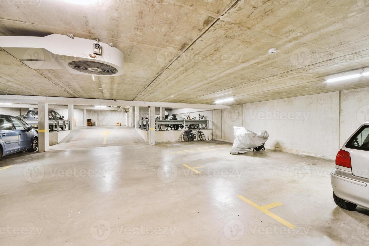 An empty parking garage with two cars parked in it photo
