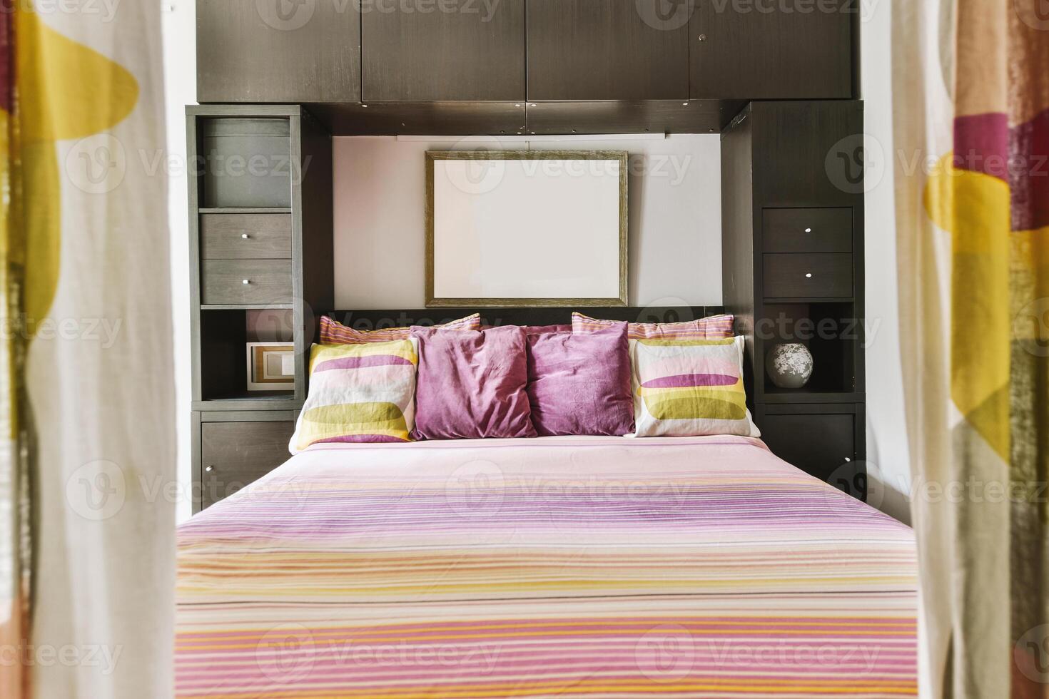 A bed with colorful bedding and a mirror photo